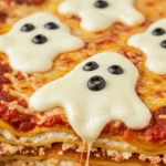 Ghostly Lasagna with mozzarella ghosts and olive eyes