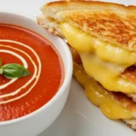 Tomato Soup and Grilled Cheese close-up with cheddar pull